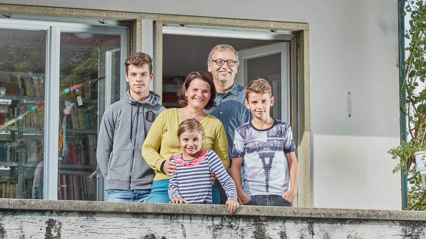 Familie Batzli lächelt auf dem Balkon