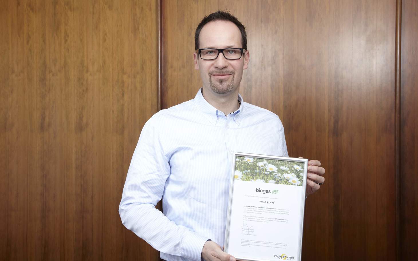 Bernhard Mollet mit biogas Zertifikat vor Kaffeebohnen